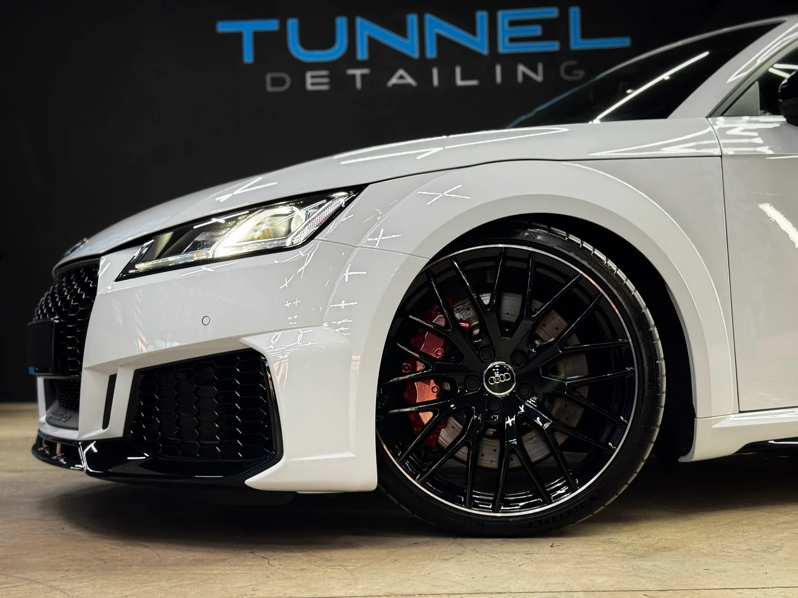 Audi blanco: aleta delantera y rueda bajo el rótulo Tunnel